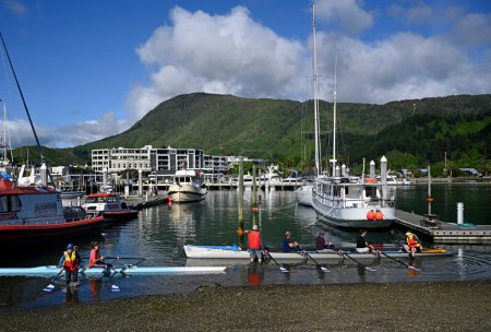 Photo for Picton, New Zealand - November 18, 2023; Women rowers preparing to launch their boat in Picton, Marlborough Sounds, New Zealand. - Royalty Free Image