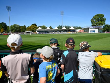 Photo for Christchurch, New Zealand  - March 10, 2024; Cricket - NZ vs Australia Test Match at the Hagley Oval. Boys enjoying the game from the bank. - Royalty Free Image