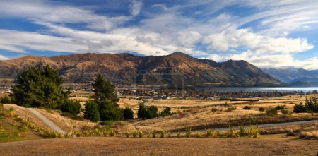 Panorama of Lake Wanaka, Township, fields and mountains, in Autumn, New Zealand