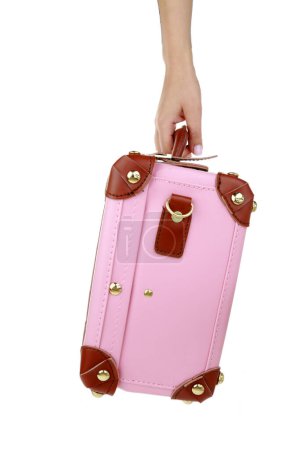Photo for Travel concept. Female hand holding a pink suitcase isolated on white transparent background - Royalty Free Image