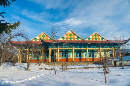 Photo for The Dungan Mosque, a vibrant wooden structure in Karakol, exhibits distinctive Chinese Muslim craftsmanship, with colorful geometric patterns adorning its facade, Islamic, minaret, snow, bright sky. - Royalty Free Image