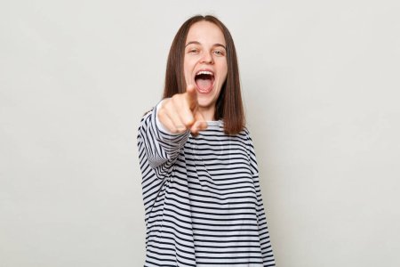 Photo for Choosing you. Excited amazed positive brown haired woman wearing striped shirt posing isolated over gray background pointing at camera saying need you - Royalty Free Image