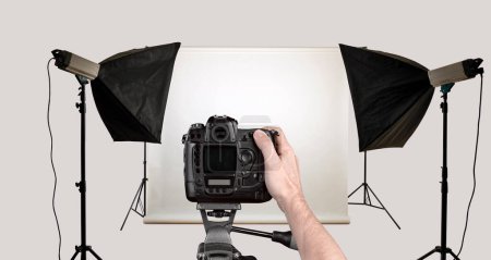 Téléchargez les photos : Tournage à la main masculin avec caméra noire en studio photo. Isolé avec chemin de coupe - en image libre de droit