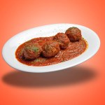 Floating White plate with Beef meats balls and tomato sausage on orange gradient background
