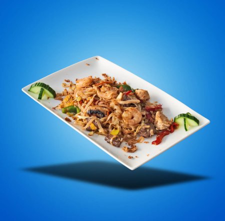 Photo for Floating Pad Thai on White Plate on blue gradient background - Royalty Free Image