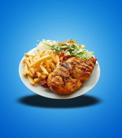 Photo for Floating of Piri Piri Chicken on white plate on blue gradient background - Royalty Free Image