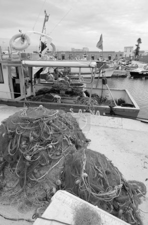 Foto de Italia, Sicilia, mar Mediterráneo, archipiélago de Egadi, isla de Favignana (provincia de Trapani); barcos de pesca y redes en el puerto - Imagen libre de derechos