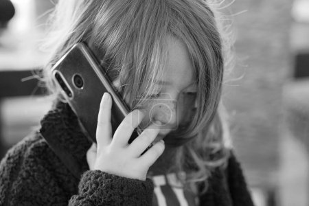 Italia, Sicilia; niño varón de 8 años hablando por teléfono en casa