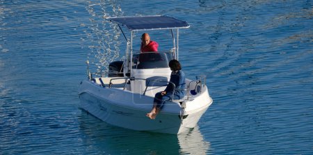 Foto de Italia, Sicilia, Mar Mediterráneo, Marina di Ragusa (Provincia de Ragusa); 12 de mayo de 2024, pareja en un barco a motor en el puerto - EDITORIAL - Imagen libre de derechos