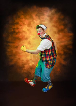Téléchargez les photos : Un clown drôle avec une expression joyeuse souriante, à fond coloré - en image libre de droit