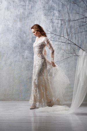 Téléchargez les photos : Pleine longueur de joyeuse mariée d'âge moyen en robe de mariée blanche studio tourné - en image libre de droit