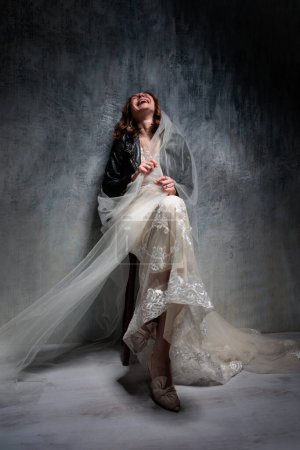 Téléchargez les photos : Pleine longueur de joyeuse mariée d'âge moyen en robe de mariée blanche studio tourné - en image libre de droit