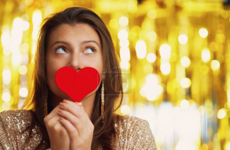 Téléchargez les photos : Jeune femme avec coeur sur fond d'or. Photo de haute qualité - en image libre de droit