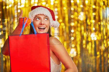 Photo for Young woman with shopping bags over gold background. High quality photo - Royalty Free Image