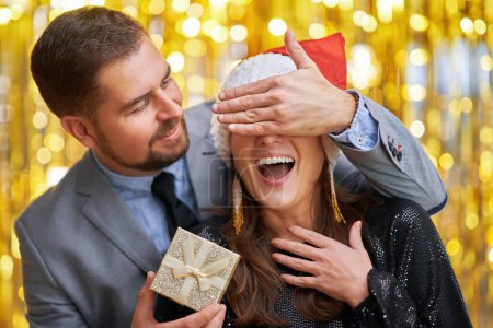 Téléchargez les photos : Couple avec cadeau d'or sur le nouvel an ou fête de Noël. Photo de haute qualité - en image libre de droit