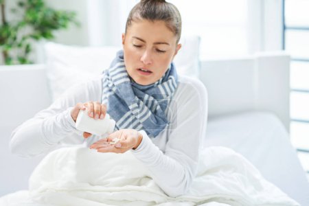 Photo for Young brunet woman sick in the bed taking medicine. High quality photo - Royalty Free Image