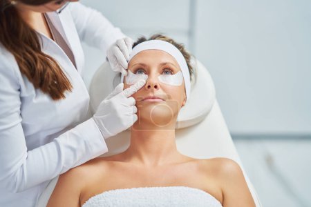 Foto de Woman having cosmetology eyebrows treatment in beauty salon. High quality photo - Imagen libre de derechos