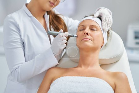 Foto de Woman in a beauty salon having needle mesotherapy treatment. High quality photo - Imagen libre de derechos