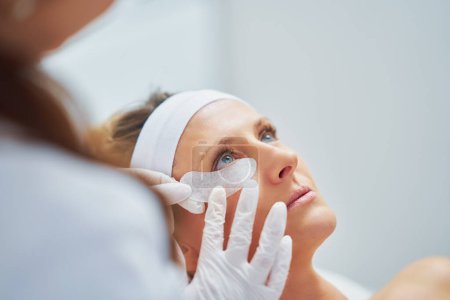 Foto de Woman having cosmetology eyebrows treatment in beauty salon. High quality photo - Imagen libre de derechos
