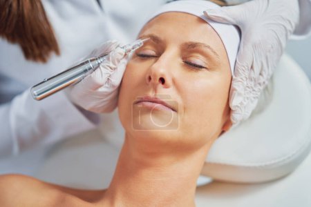 Téléchargez les photos : Woman having permanent eyebrows cosmetology treatment. High quality photo - en image libre de droit