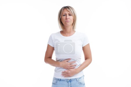 Foto de Imagen de una mujer rubia sobre un fondo aislado con problemas estomacales. Foto de alta calidad - Imagen libre de derechos