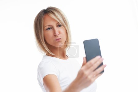 Foto de Picture of blonde woman over back isolated background with mobile phone. High quality photo - Imagen libre de derechos