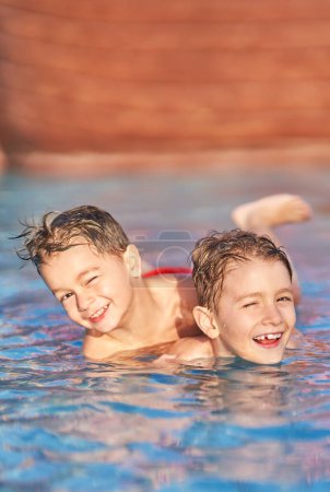 Téléchargez les photos : Photo de frères jouant dans la piscine extérieure du parc aquatique. Photo de haute qualité - en image libre de droit