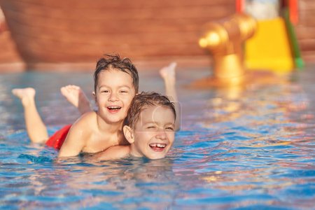 Photo for Picture of brothers playing in outdoor aqua park pool. High quality photo - Royalty Free Image