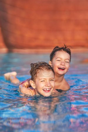 Foto de Foto de hermanos jugando en la piscina al aire libre del parque acuático. Foto de alta calidad - Imagen libre de derechos