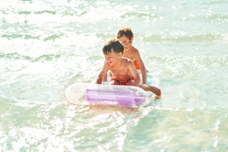 Téléchargez les photos : Deux garçons ou frères sur un matelas sur la mer Rouge. Photo de haute qualité - en image libre de droit
