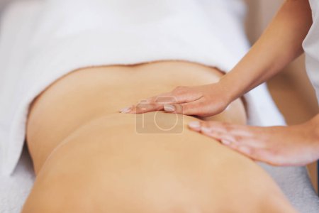 Téléchargez les photos : Brunette femme ayant massage du dos dans le salon. Photo de haute qualité - en image libre de droit