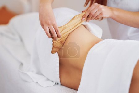 Mujer en terapia de masaje con herramientas de madera. Foto de alta calidad