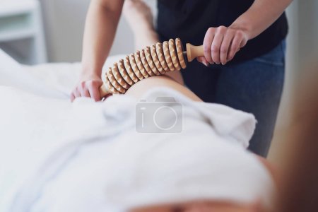 Mujer en terapia de masaje con herramientas de madera. Foto de alta calidad
