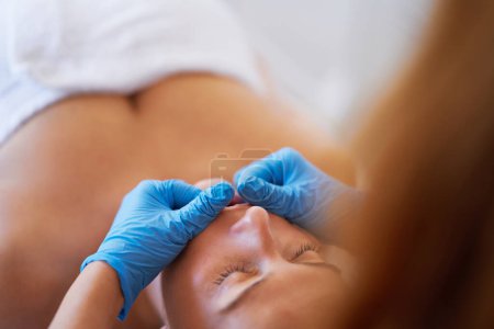 Mujer recibiendo masaje en la boca con guantes azules. Foto de alta calidad