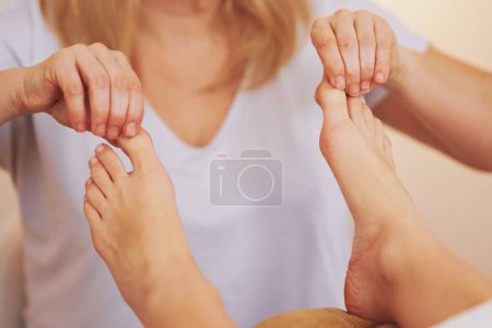 Téléchargez les photos : Femme ayant massage de réflexologie des pieds dans le salon. Photo de haute qualité - en image libre de droit
