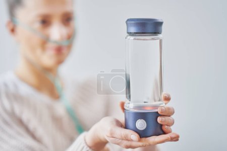 Téléchargez les photos : Photo d'une femme ayant de l'eau d'hydrogène à la main. Photo de haute qualité - en image libre de droit
