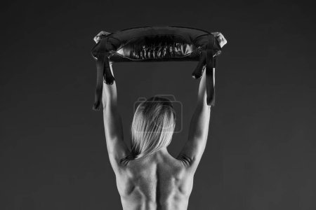 Foto de Foto de mujer rubia atractiva haciendo entrenamiento con bolsa de arena. Foto de alta calidad - Imagen libre de derechos