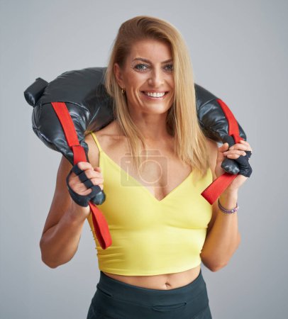 Foto de Foto de mujer rubia atractiva haciendo entrenamiento con bolsa de arena. Foto de alta calidad - Imagen libre de derechos