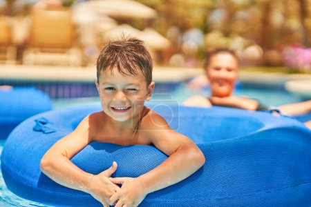 Téléchargez les photos : Photo d'un petit garçon s'amusant en aquapark en plein air sur tube. Photo de haute qualité - en image libre de droit