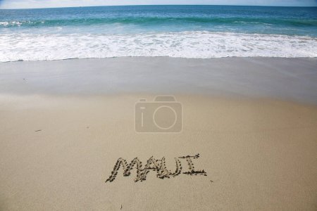 Photo for Maui written in the sand on the beach.  message handwritten on a smooth sand beach - Royalty Free Image