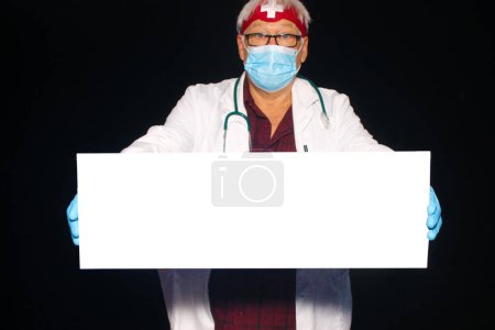 Photo for Medical. A friendly and kindly doctor smiles on a black background. Smiling Caucasian male doctor wearing a white medical uniform and stethoscope. Friendly Doctor. - Royalty Free Image