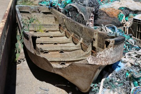 Téléchargez les photos : Bateau cassé. Un vieux bateau cassé jeté dans une poubelle sur le côté d'un quai. Old Broken Boats ne sont d'aucune utilité pour les pêcheurs ou les gens. - en image libre de droit