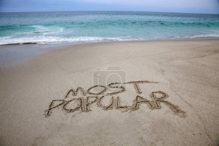 Téléchargez les photos : Most popular written in the sand on the beach.  message handwritten on a smooth sand beach - en image libre de droit