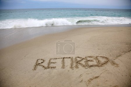 Téléchargez les photos : Retired written in the sand on the beach.  message handwritten on a smooth sand beach - en image libre de droit