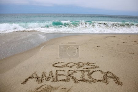 Téléchargez les photos : God's america  written in the sand on the beach.  message handwritten on a smooth sand beach - en image libre de droit