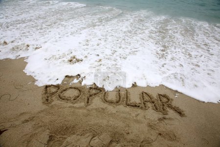 Téléchargez les photos : Popular written in the sand on the beach.  message handwritten on a smooth sand beach - en image libre de droit