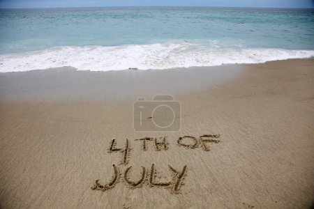 Photo for 4th of july written in the sand on the beach.  message handwritten on a smooth sand beach - Royalty Free Image