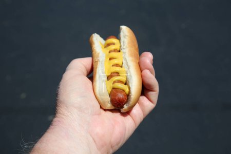 Foto de Hot dog with  sausage  in male hand - Imagen libre de derechos
