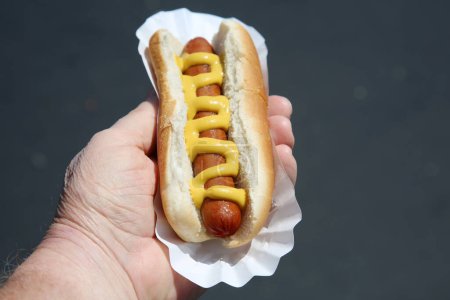Foto de Hot dog with  sausage  in male hand - Imagen libre de derechos