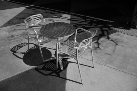 Photo for Table and Chairs. Patio Furniture. Aluminum Chairs  and table   on a Patio. - Royalty Free Image